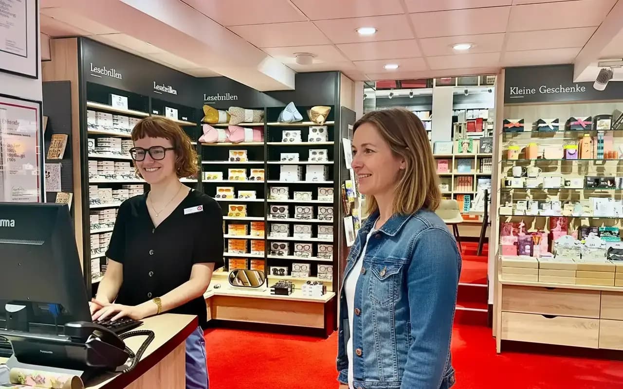 Eine Heymann-Mitarbeiterin steht an einer Info und berät eine Kundin.