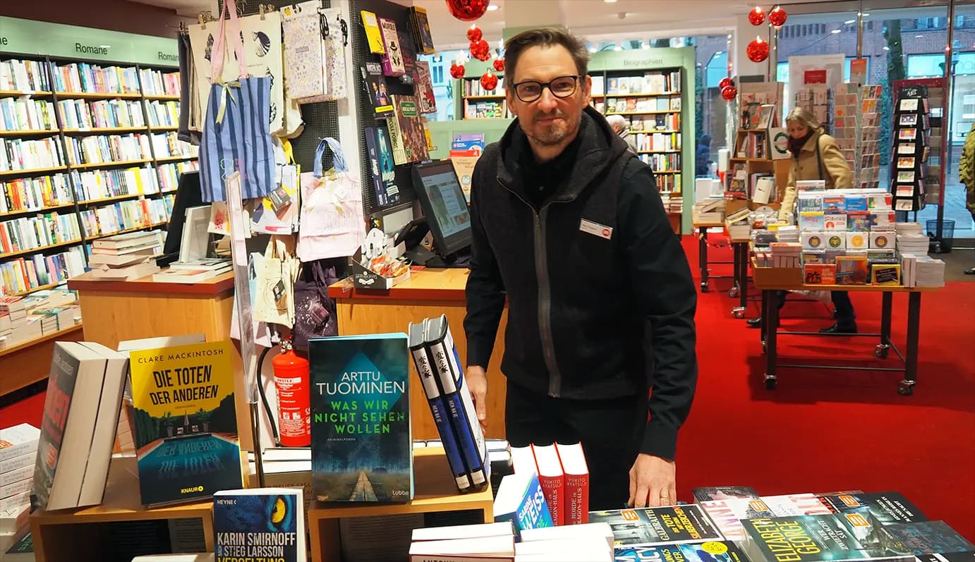 Ein Heymann-Kollege dekoriert einen Büchertisch zum Thema Krimi.